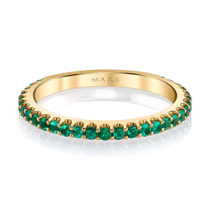 a gold band with green stones on it